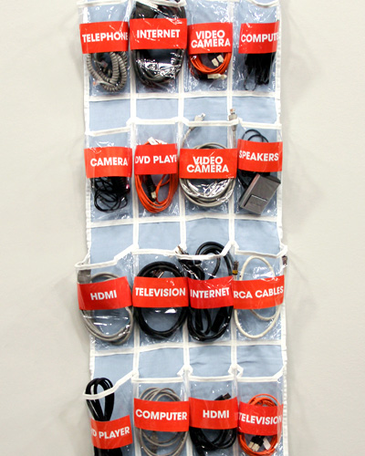 an over-the-door shoe organizer repurposed to store various cables, cords, and wires