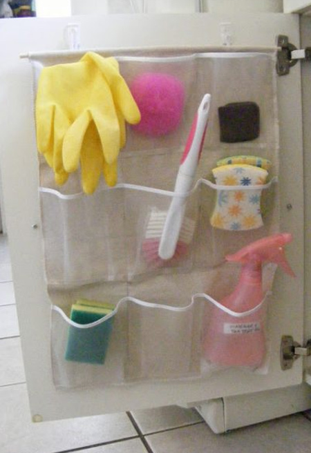 DIY pocket organizer hanging on a cabinet door and storing cleaning supplies