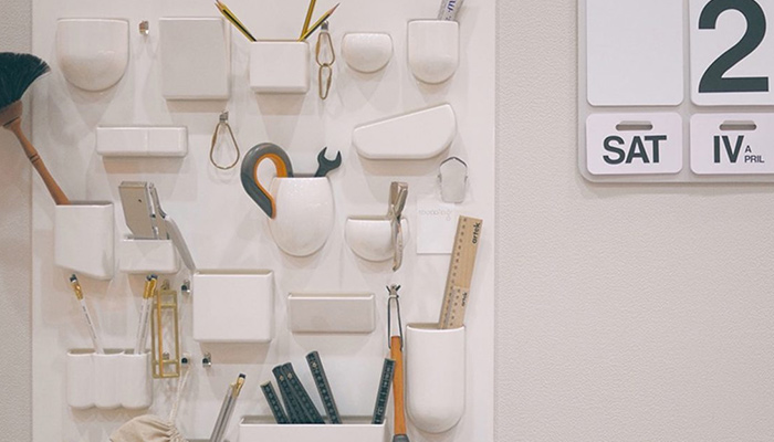 white wall organizers and a wall-mounted calendar with large numbers and letters