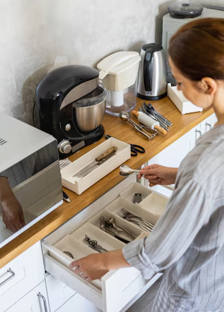 housewife tidying up kitchen cupboard