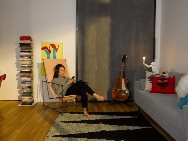 a woman wearing headphones while reading her phone and sitting in a canvas chair