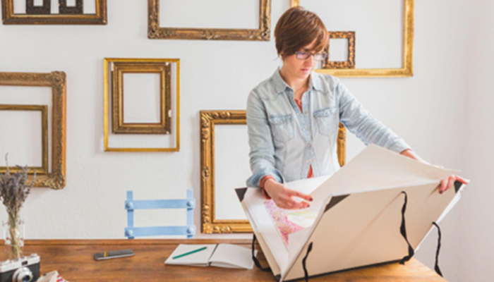 A woman storing a painting in a folder