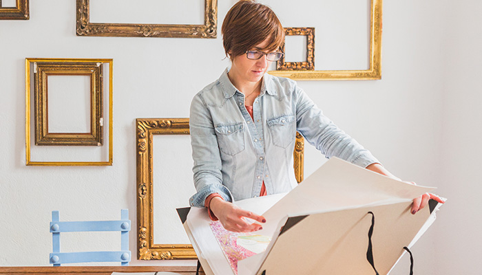 A woman storing a painting in a folder