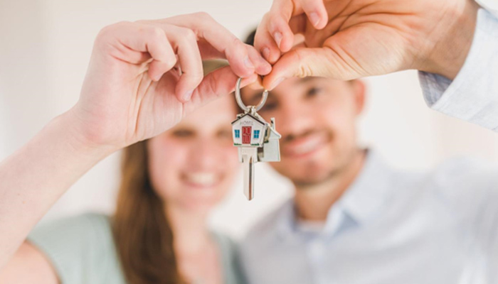 happy couple holding the keys to their new house