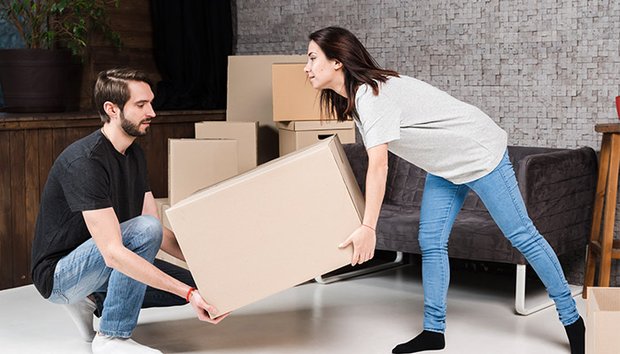 Adult man and woman carrying cardboard boxes