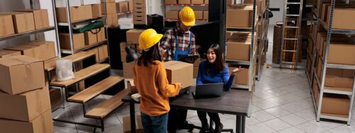 Storage facility employees in a discussion surrounded by storage boxes