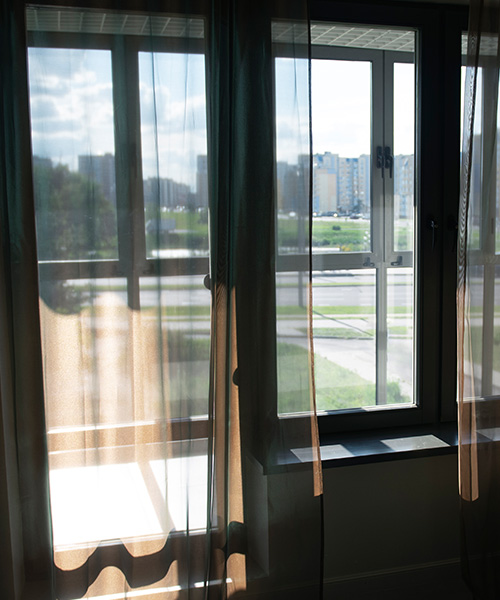 View of window with textile curtains and shadows