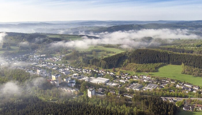 Aerial view shot of beautiful green fields and houses of the countryside on a sunny day