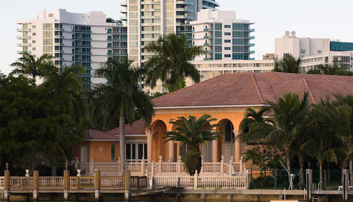 Luxury waterfront mansion with a private dock and palm trees