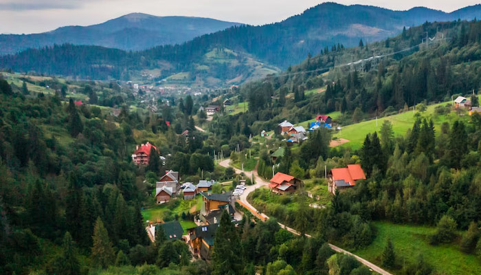 Aerial view Shot by Drone Village Small among mountains, forests