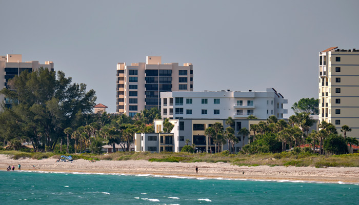 Beachfront resort with white sand, blue waters, and tall hotel buildings